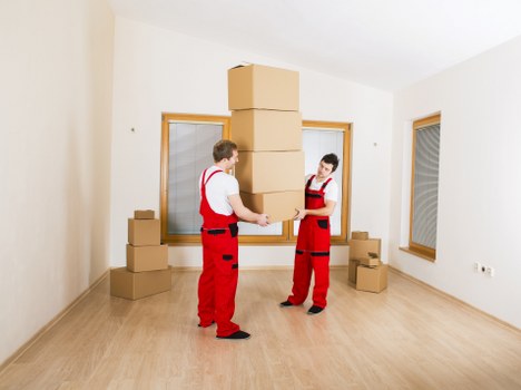 Professional movers carrying furniture through a residential property in Greenford